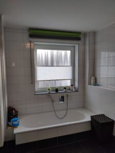 Badezimmerfenster mit maßgefertigtem Sichtschutzrollo von M-Gardindendesign.