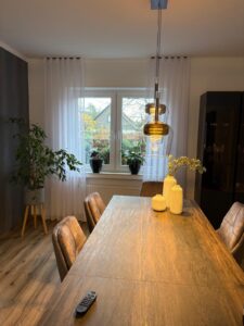 Wohn- und Essbereich mit Gardinen und stimmiger Raumgestaltung